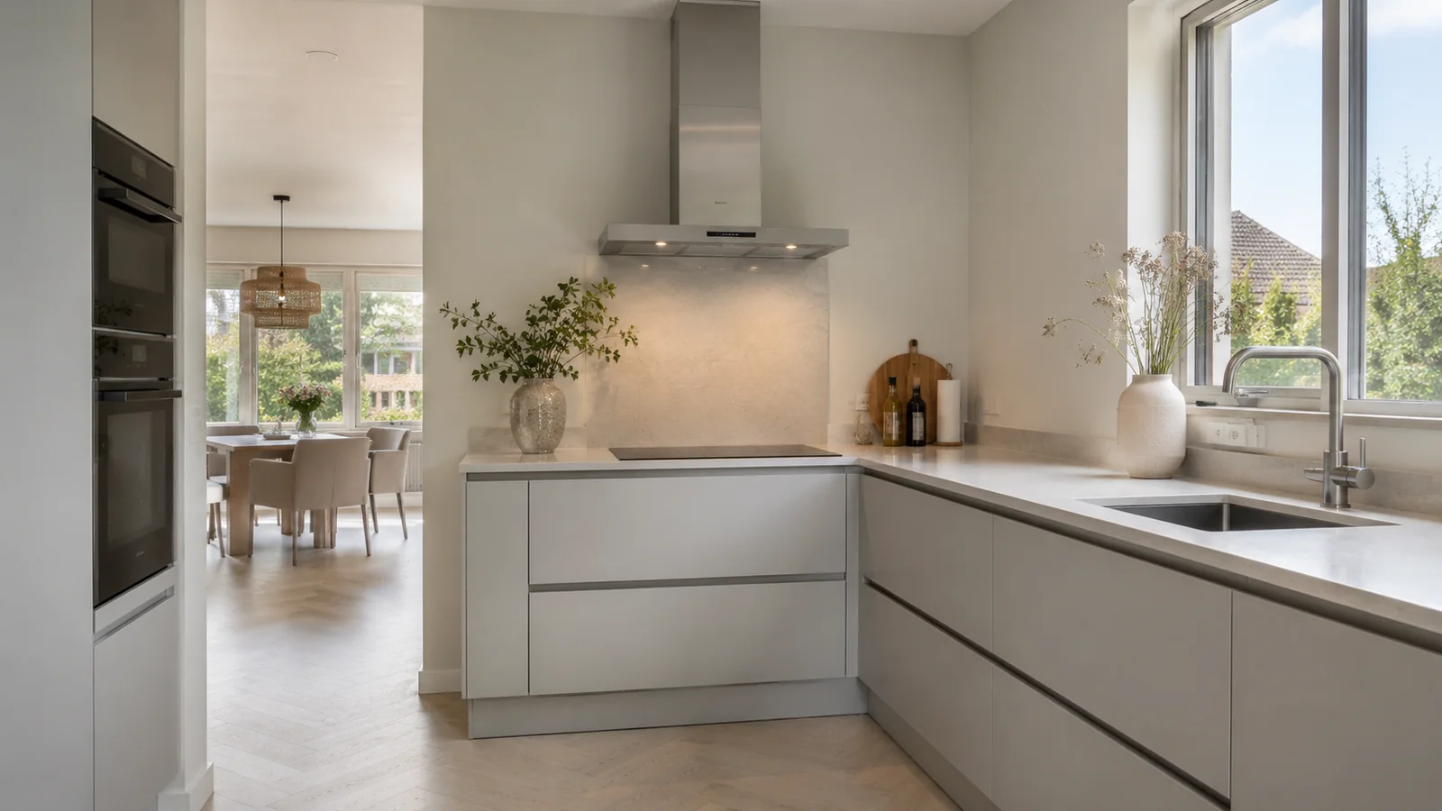 Lichtgrijze keuken met licht werkblad, open naar de eethoek