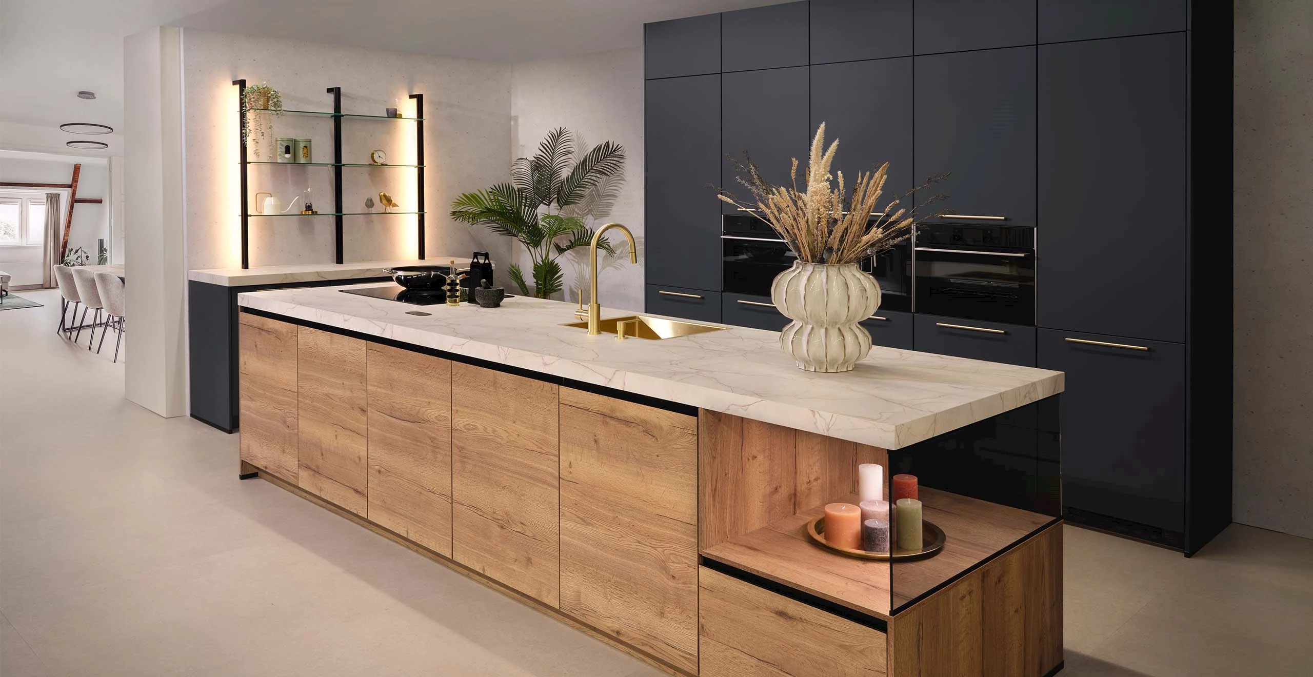 Ruime keuken met een groot kookeiland met eiken fronten en een wit marmer werkblad