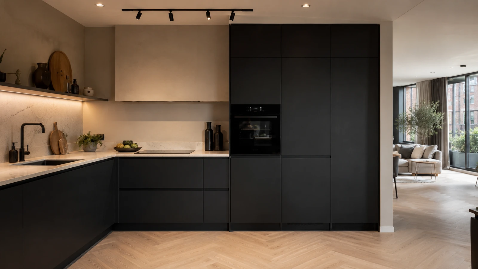 Moderne matzwarte L-keuken met een hoge kastenwand en ingebouwde oven