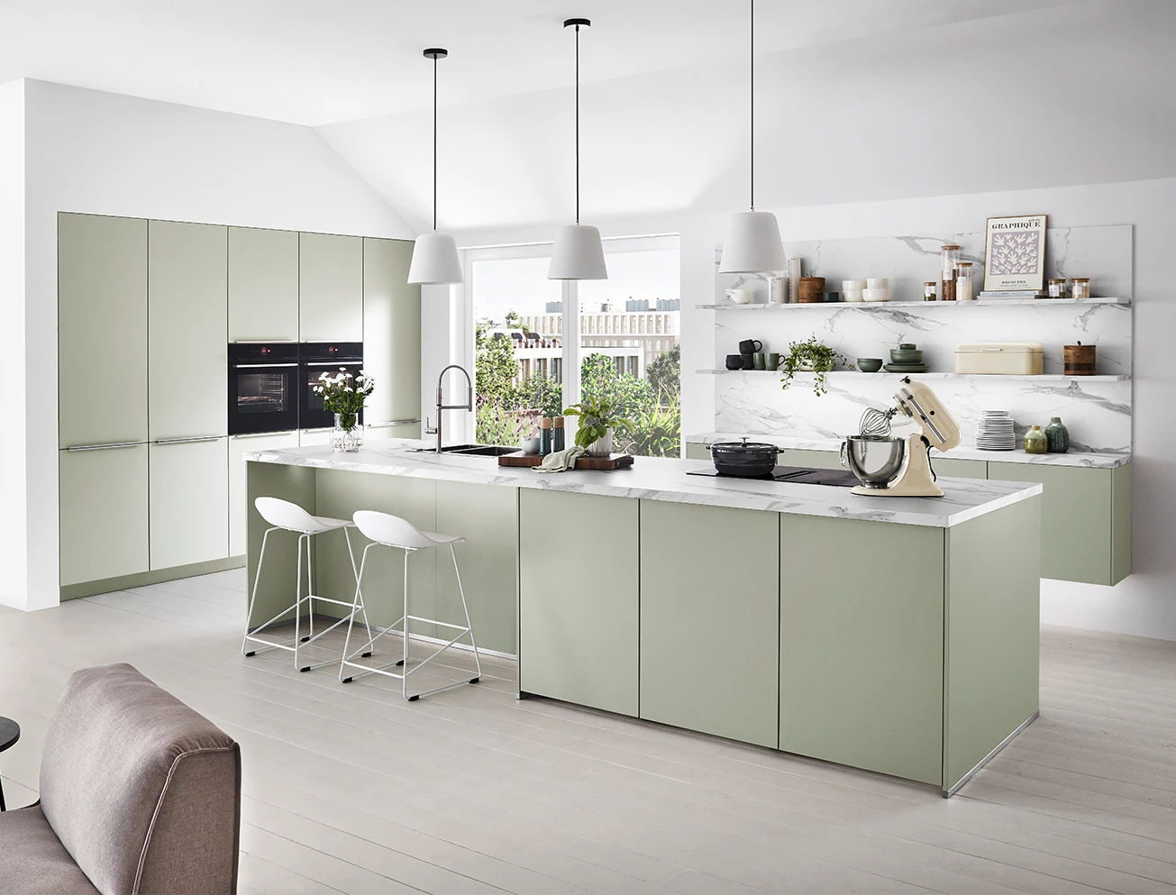 Saliegroene keuken met een groot marmeren eiland