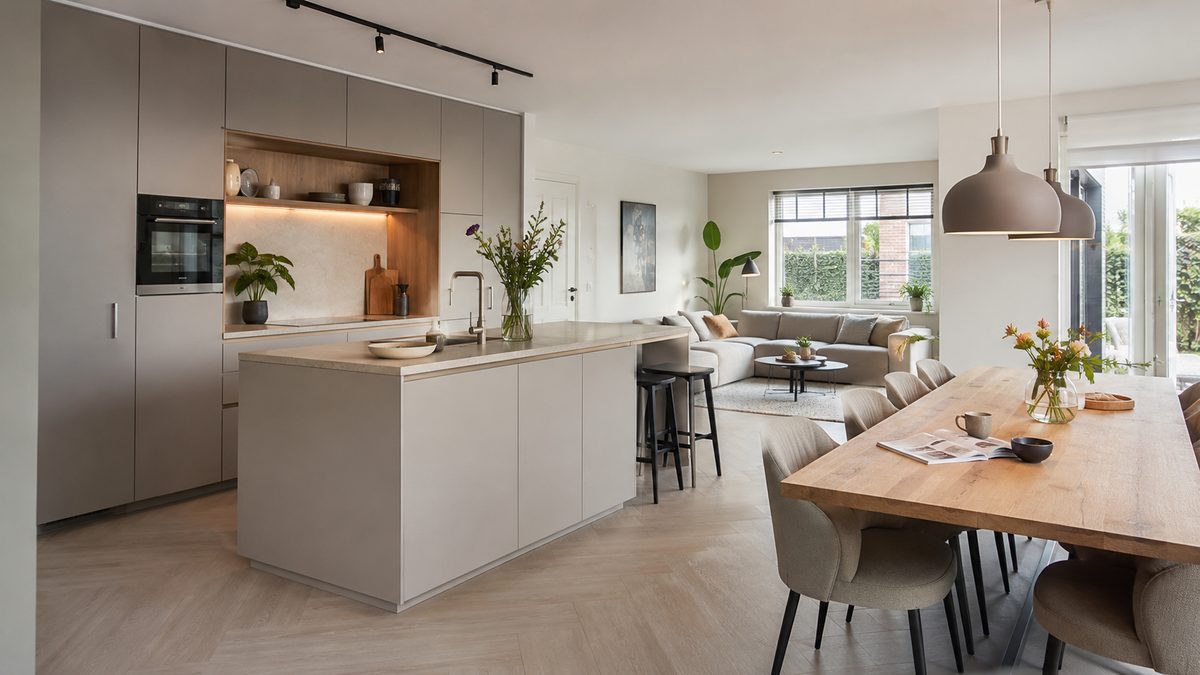 Lichte woonkeuken met een eiland, een eettafel en een zithoek in één ruimte