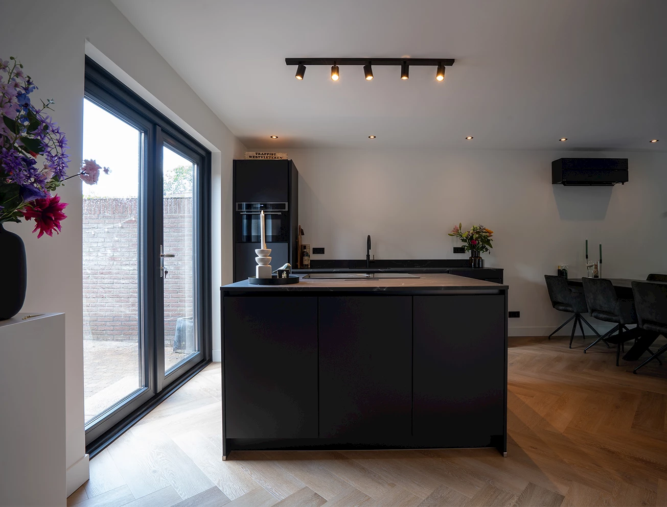 Zwarte keuken met eiland en wit werkblad