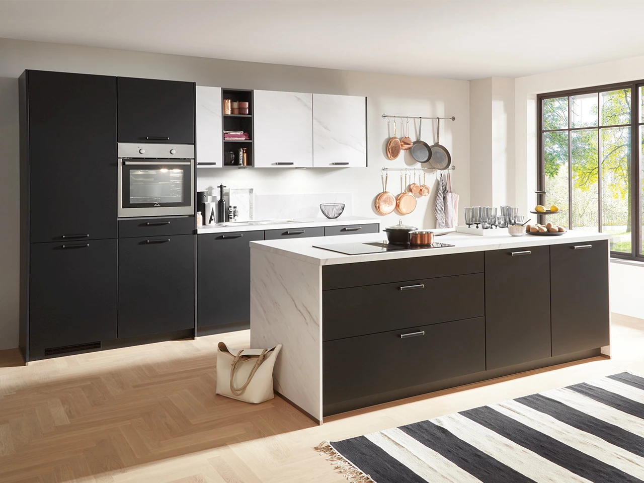 Zwarte keuken met wit marmeren eiland en koperen pannen