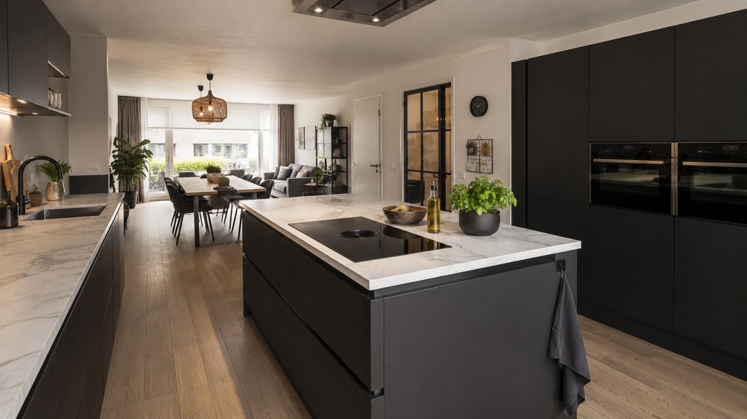 Zwarte keuken met wit marmerlook werkblad op het eiland